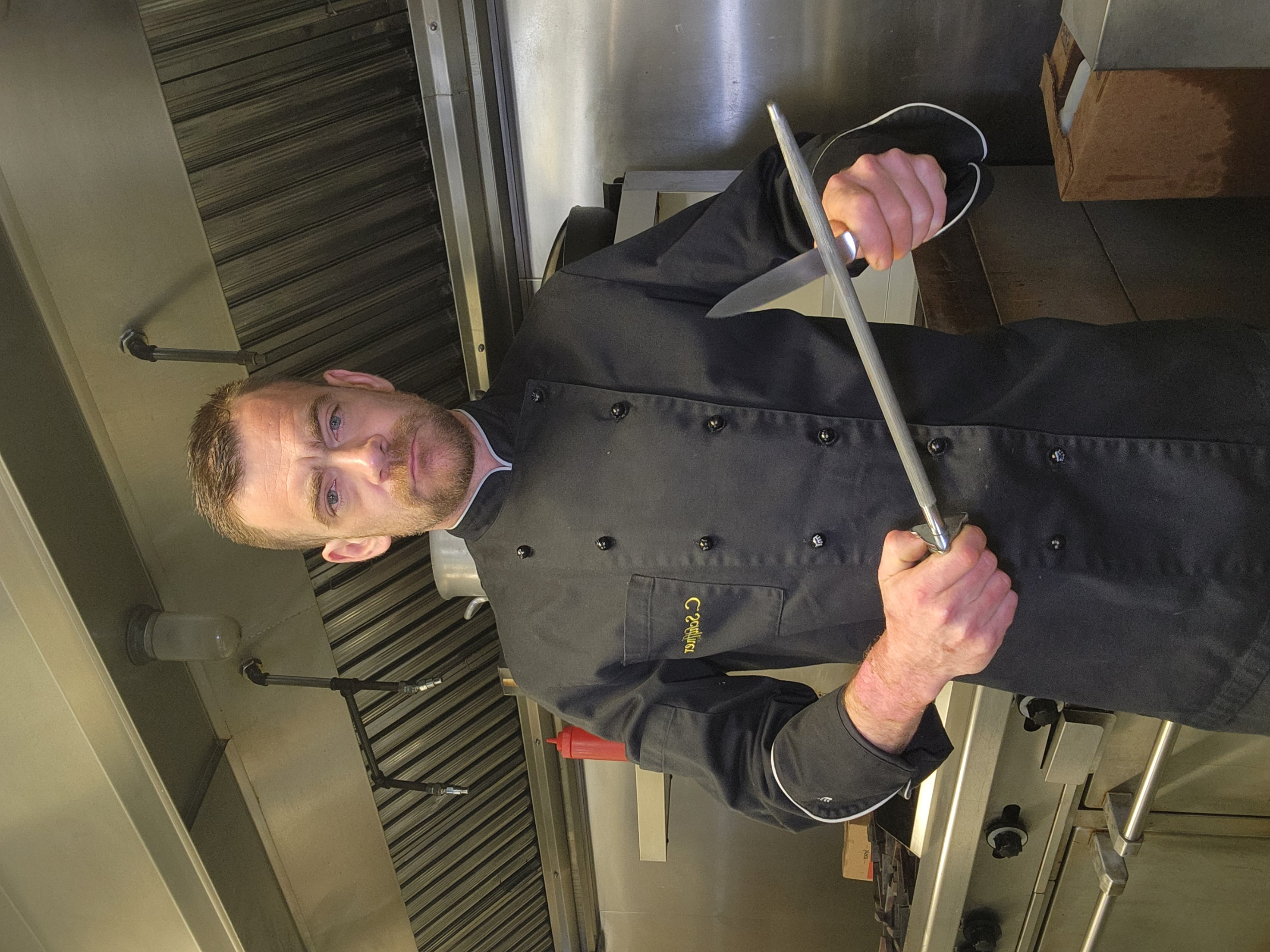 Chef Christian Schiffner sharpening a knife in the kitchen
